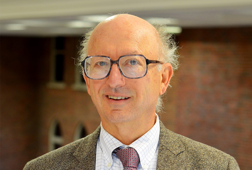 Fred Niederman, Ph.D., smiles for a photo in the atrium of Cook Hall at Saint Louis University's Chaifetz School of Business