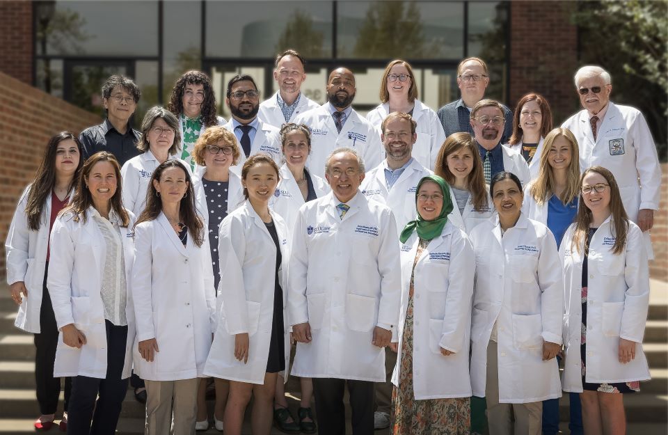 A group photo of the psychiatry faculty standing in front of the LRC