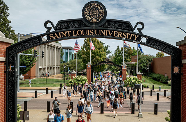 Aerial shot of students walking under SLU arches