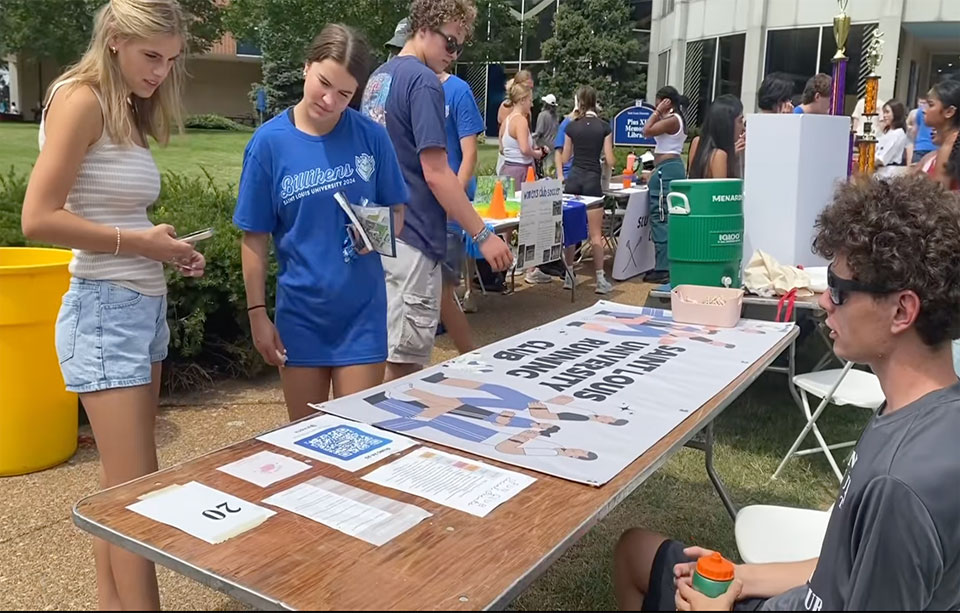 Students at a SLU Involvement Fair Table.