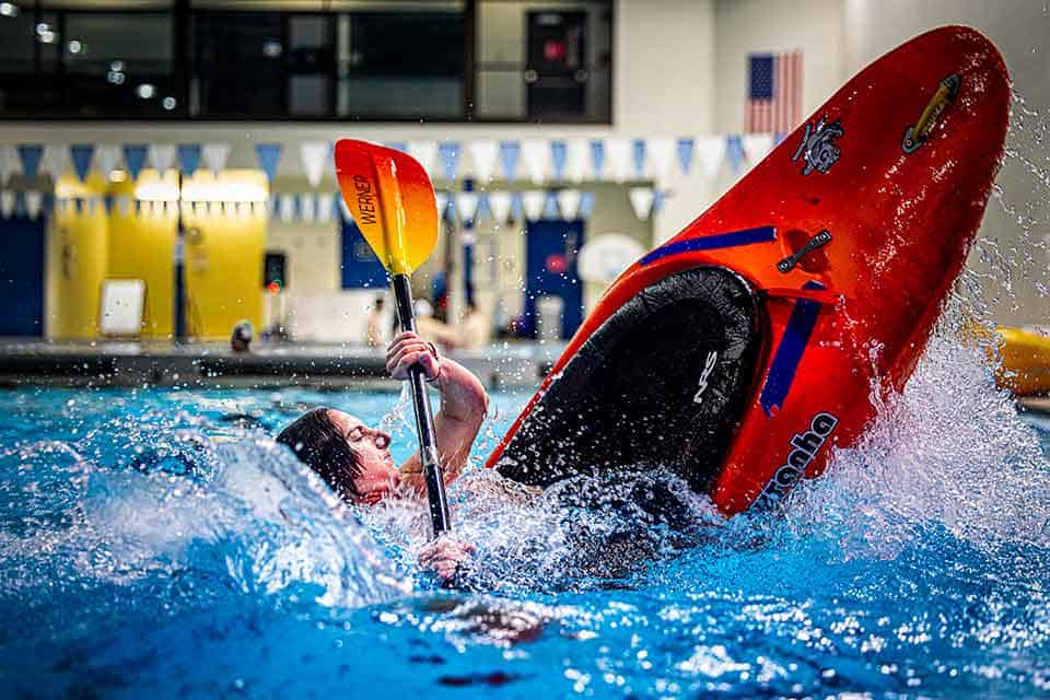 A kayaker nearly flips in their kayak while practicing in a SLU pool